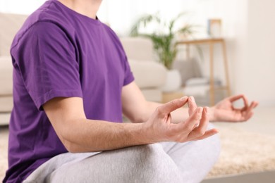 Man meditating at home, closeup. Harmony and zen
