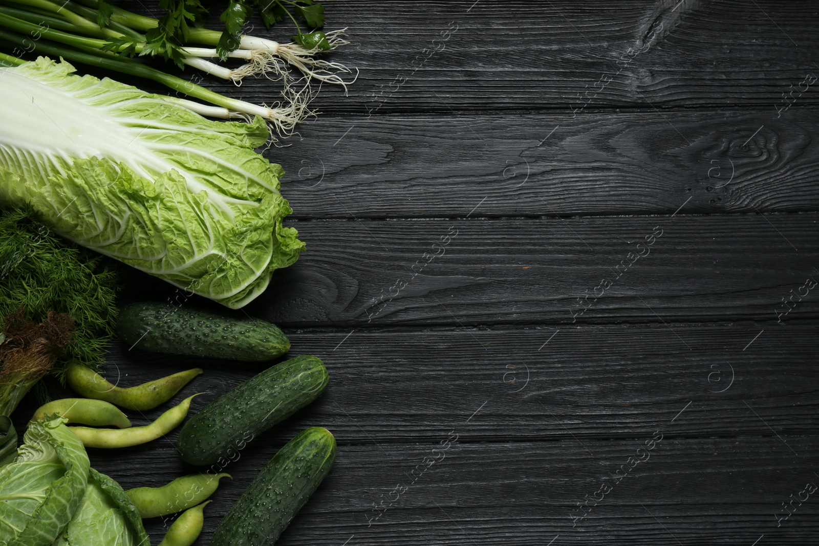 Photo of Different fresh ripe vegetables on black wooden table, flat lay with space for text. Farmer produce