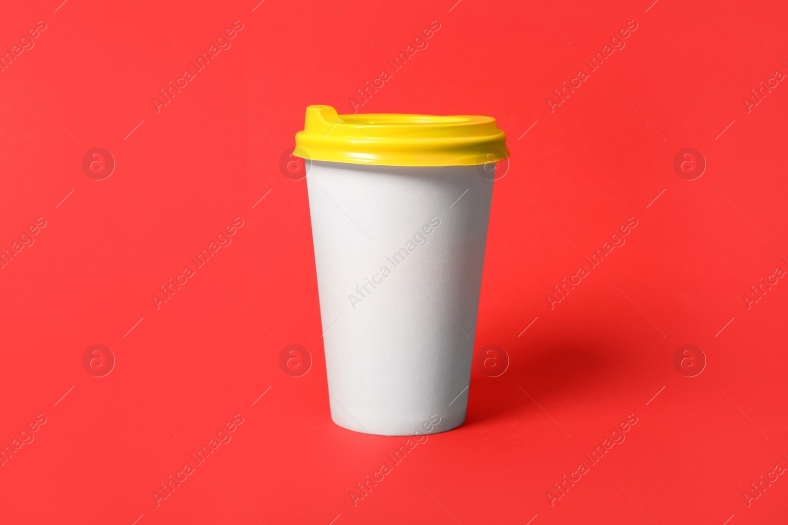 Photo of Takeaway paper coffee cup on red background