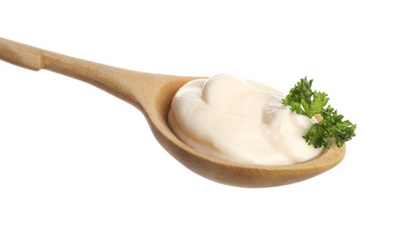 Wooden spoon with tasty mayonnaise and parsley isolated on white