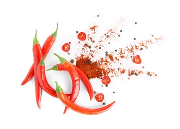 Photo of Fresh chili peppers and paprika powder on white background, top view
