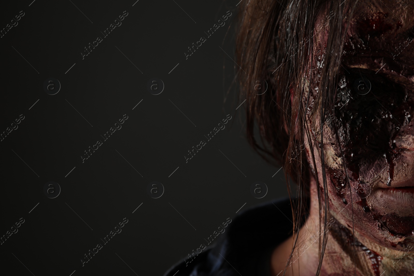 Photo of Scary zombie on dark background, closeup with space for text. Halloween monster