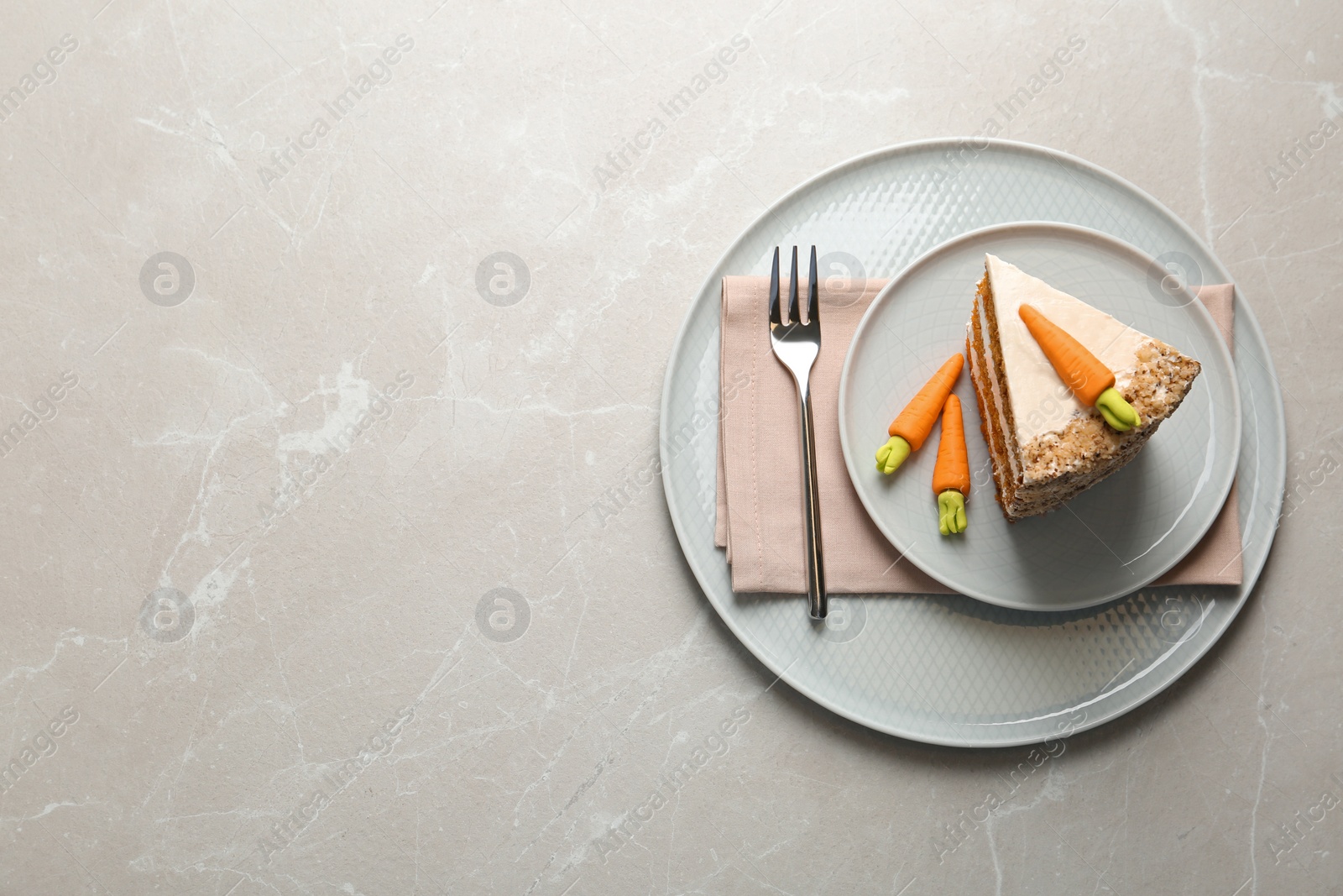 Photo of Plate with sweet carrot cake on white marble table, top view. Space for text