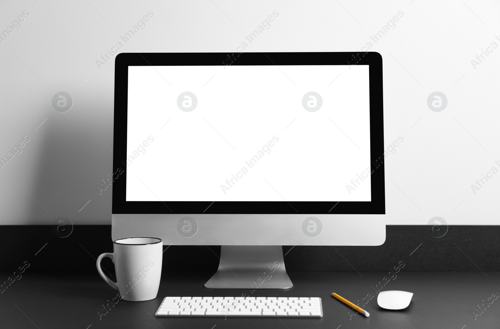 Photo of Modern computer with blank screen on black table. Mockup for design