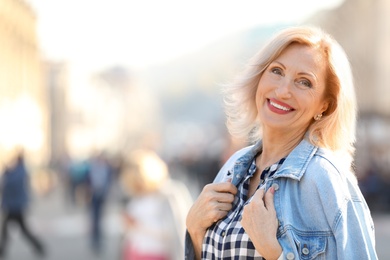 Photo of Portrait of happy mature woman on city street