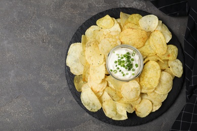 Photo of Chips with sour cream on grey table, top view