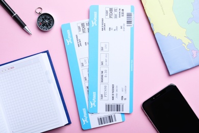 Photo of Flat lay composition with tickets on pink background. Travel agency concept