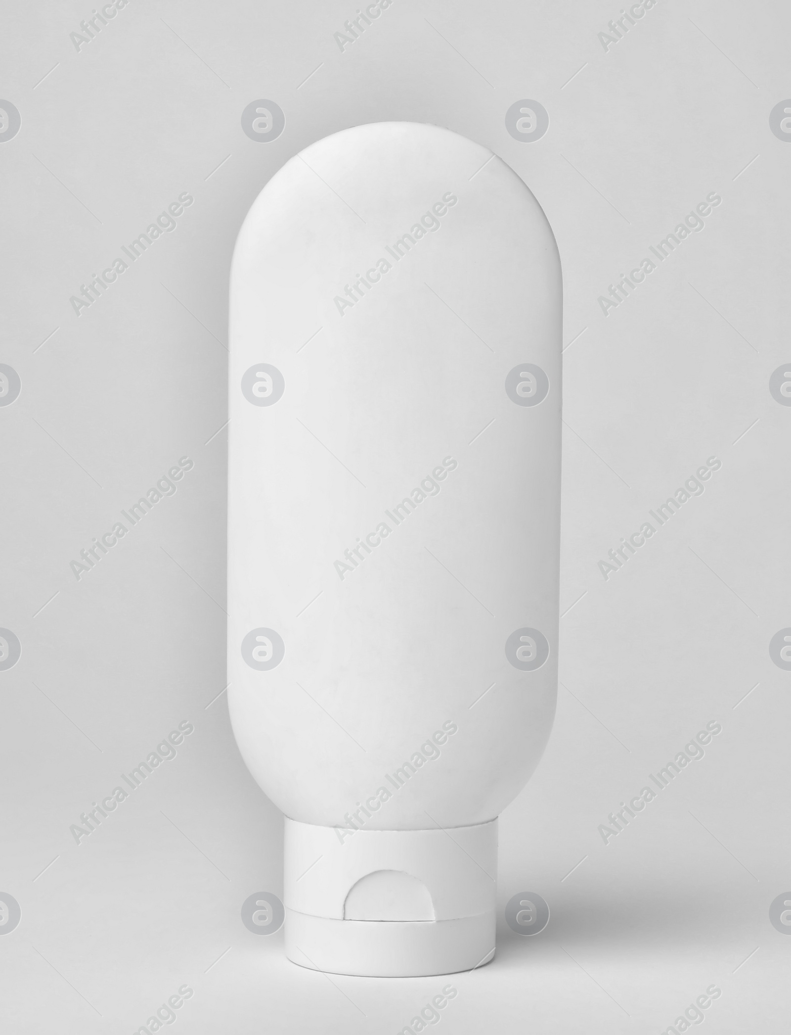 Photo of Bottle of cosmetic product on light background