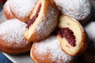 Photo of Delicious sweet buns with jam and powdered sugar, closeup