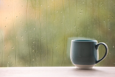 Photo of Cup of drink on windowsill, space for text. Rainy weather