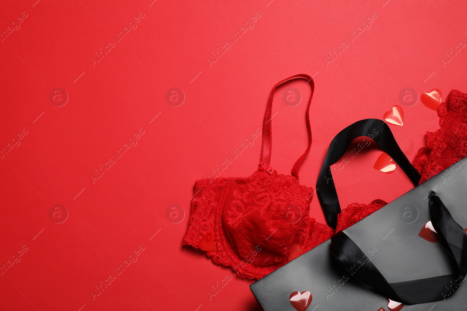 Photo of Flat lay composition with sexy lingerie on red background, space for text