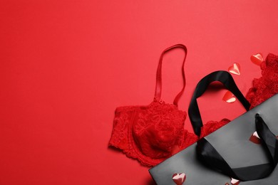 Flat lay composition with sexy lingerie on red background, space for text