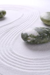 Photo of Stones on sand with pattern. Zen concept