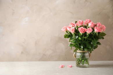 Photo of Vase with beautiful rose flowers on table