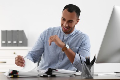 Photo of Happy businessman working with documents at table in office