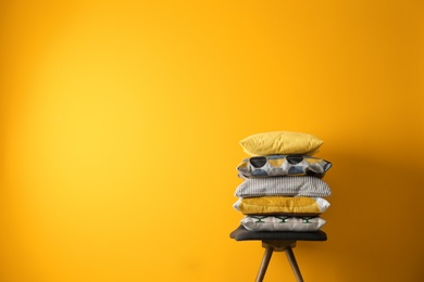 Photo of Chair with many different pillows and space for text on color background