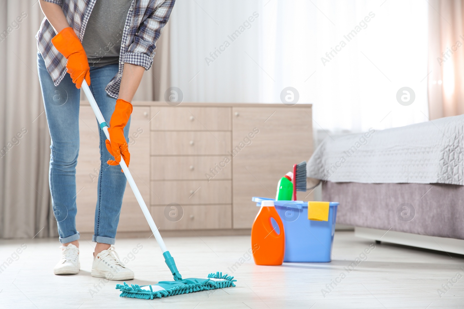 Photo of Young woman washing floor with mop in bedroom, closeup with space for text. Cleaning service