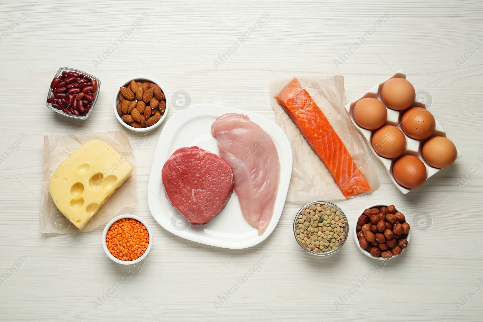 Photo of Different fresh products on white wooden table, flat lay. Sources of essential amino acids