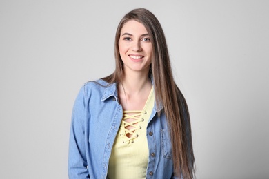 Photo of Portrait of young woman with long beautiful hair on light background