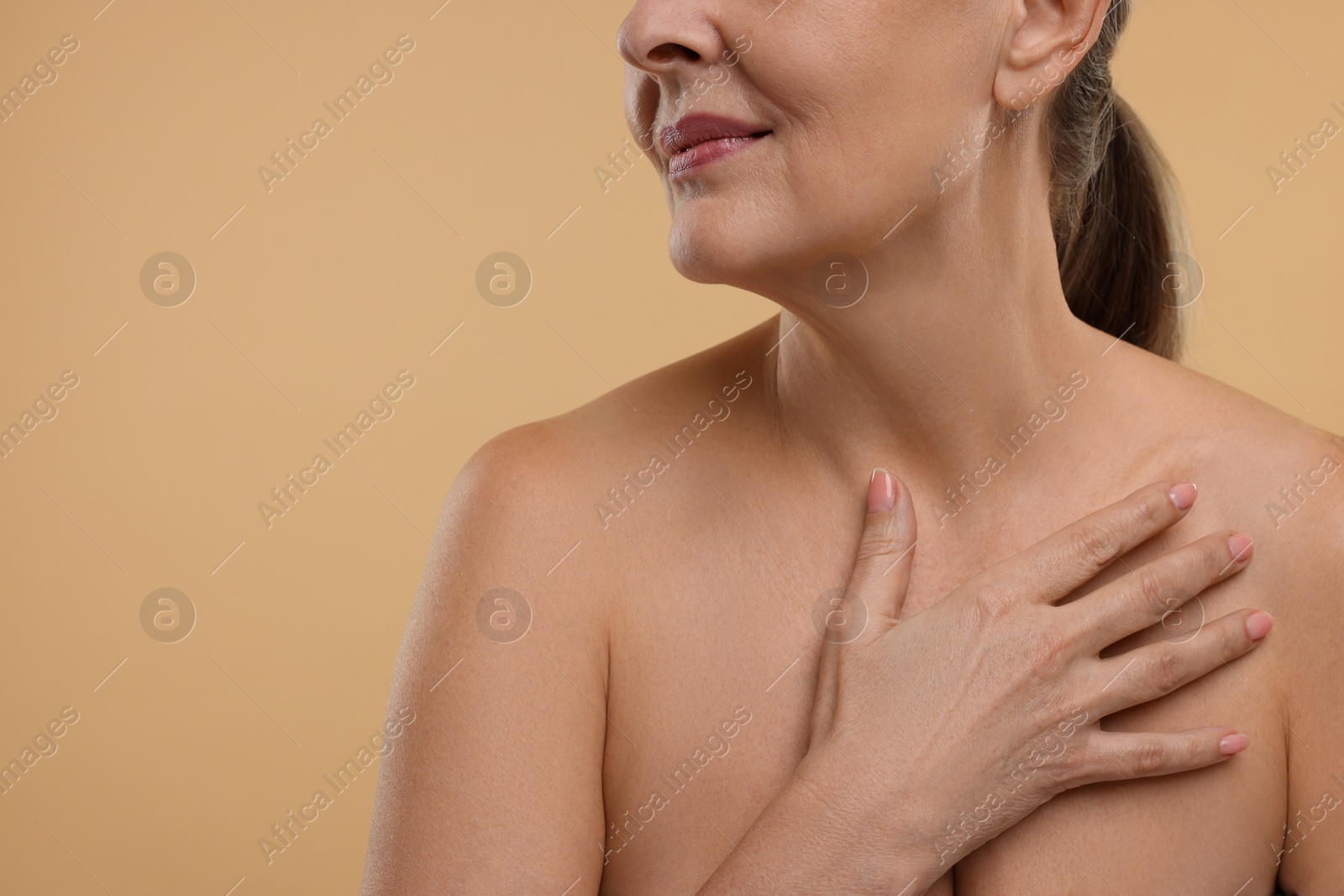 Photo of Mature woman with healthy skin on beige background, closeup. Space for text