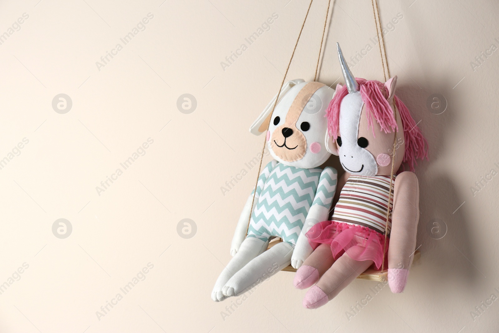 Photo of Shelf with cute toys on beige wall, space for text. Child's room interior element