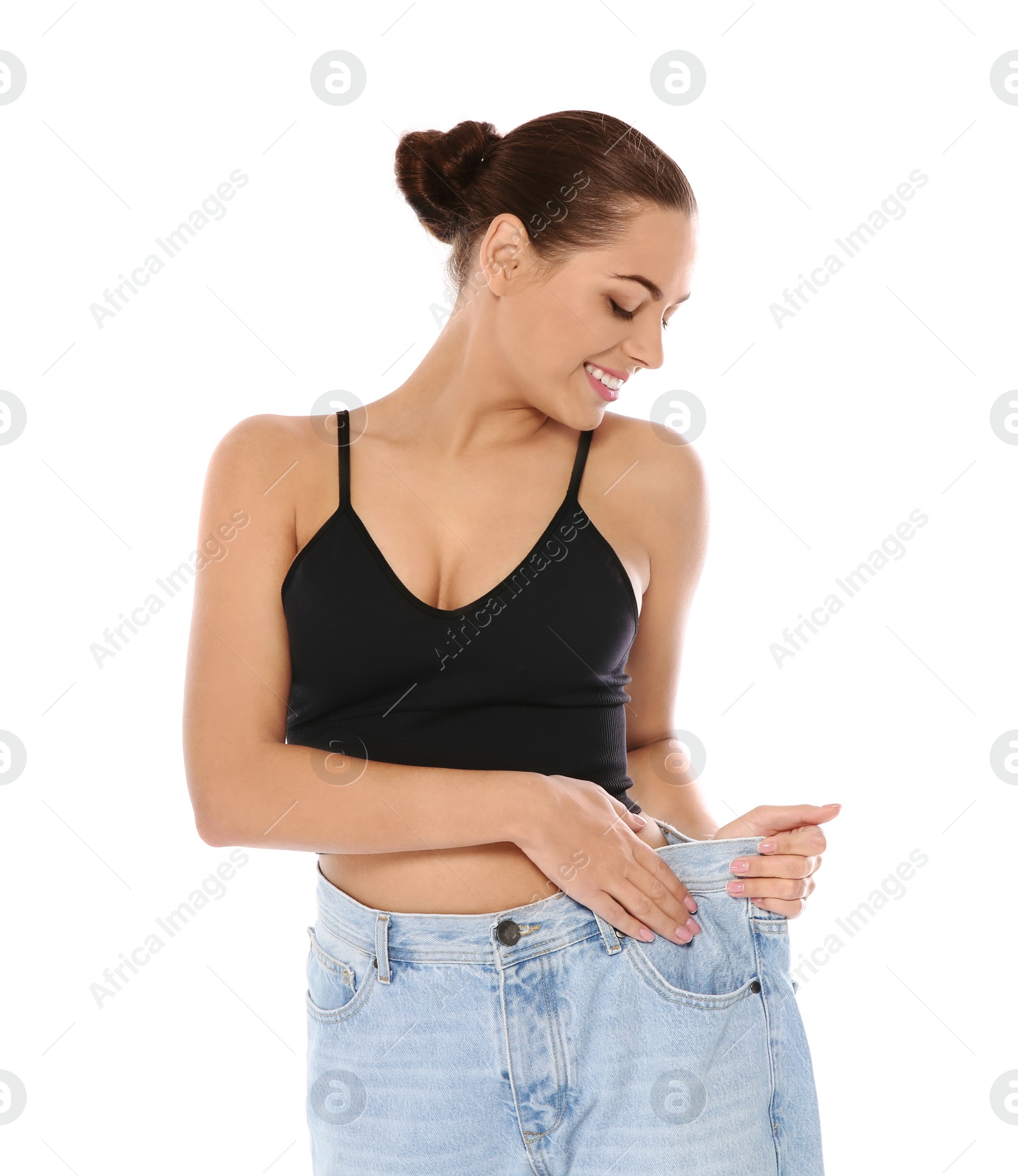 Photo of Slim woman in oversized jeans on white background. Weight loss