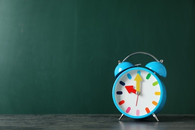 Photo of Alarm clock on table against color background. Time concept