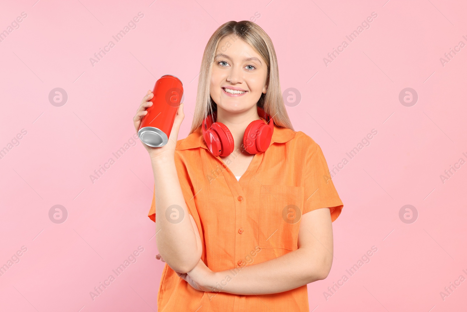 Photo of Beautiful happy woman holding red beverage can on pink background