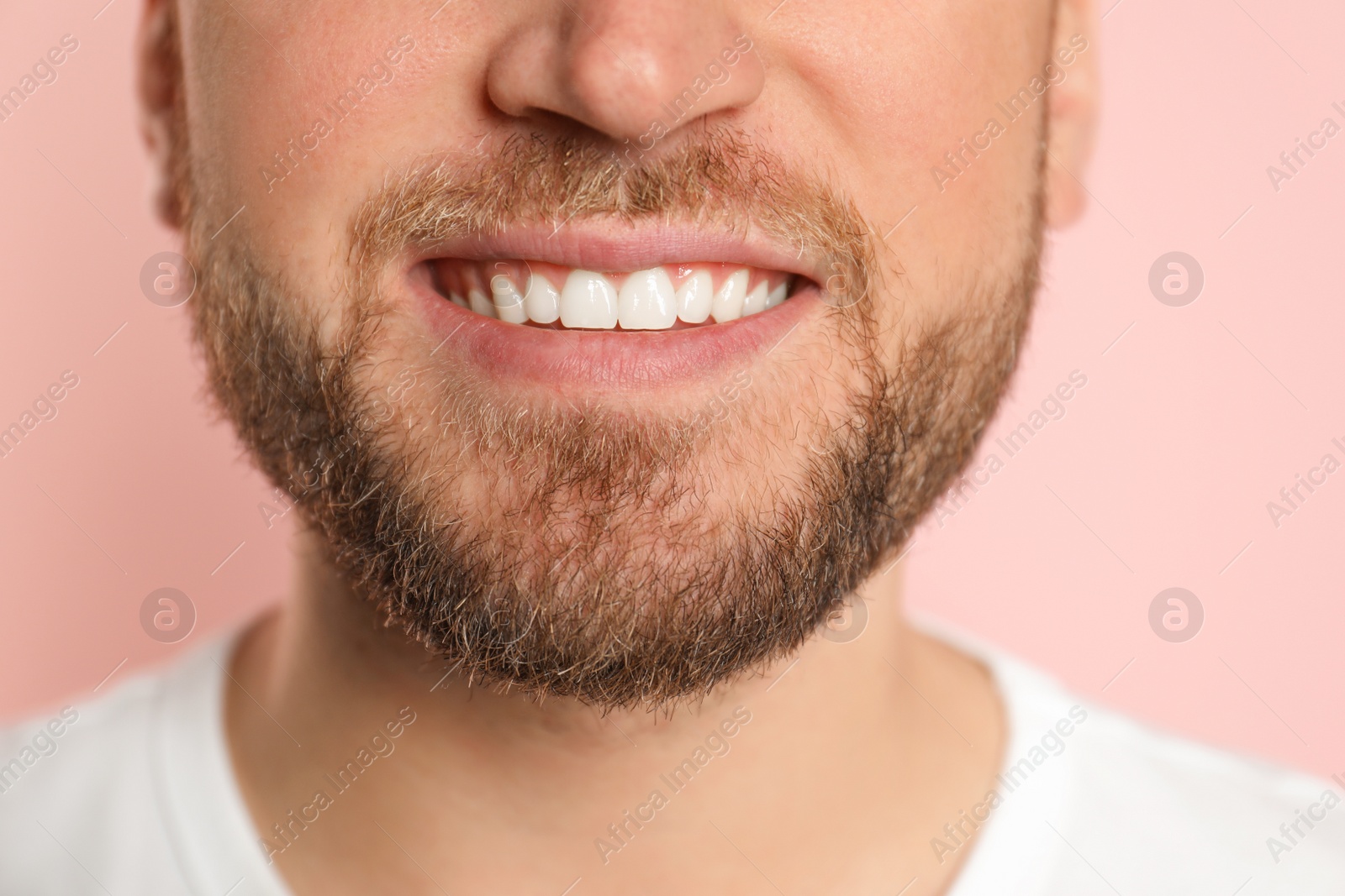 Photo of Young man with healthy teeth on color background, closeup