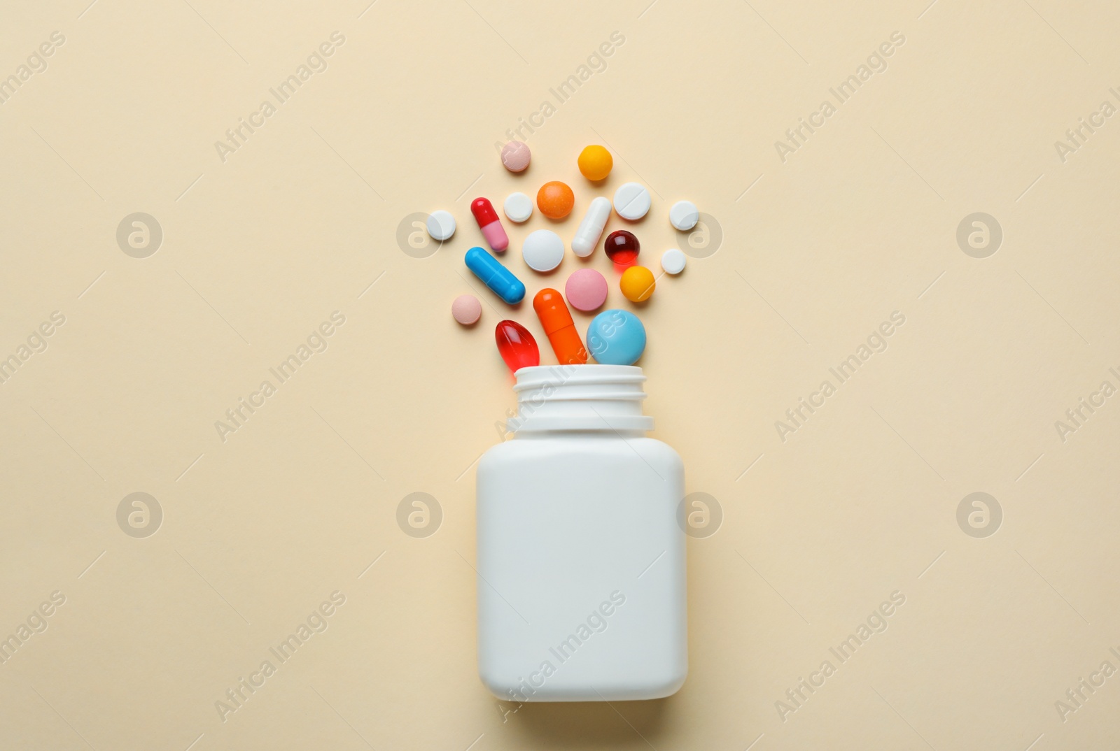 Photo of Bottle with different pills on color background, flat lay