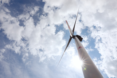 Modern wind turbine against cloudy sky, low angle view. Alternative energy source