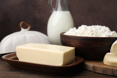 Photo of Dairy products. Cottage cheese, butter and milk on wooden table, closeup