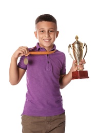 Photo of Happy boy with golden winning cup and medal on white background