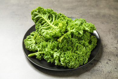 Photo of Fresh green kale leaves on grey table