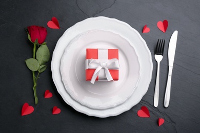 Photo of Beautiful table setting for Valentine's Day dinner on black background, flat lay