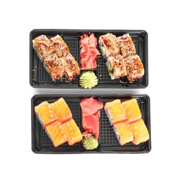 Photo of Boxes with tasty sushi rolls on white background, top view. Food delivery