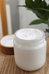 Photo of Jar of hand cream on wooden table indoors