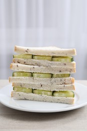 Photo of Tasty sandwiches with cream cheese and cucumber on white wooden table