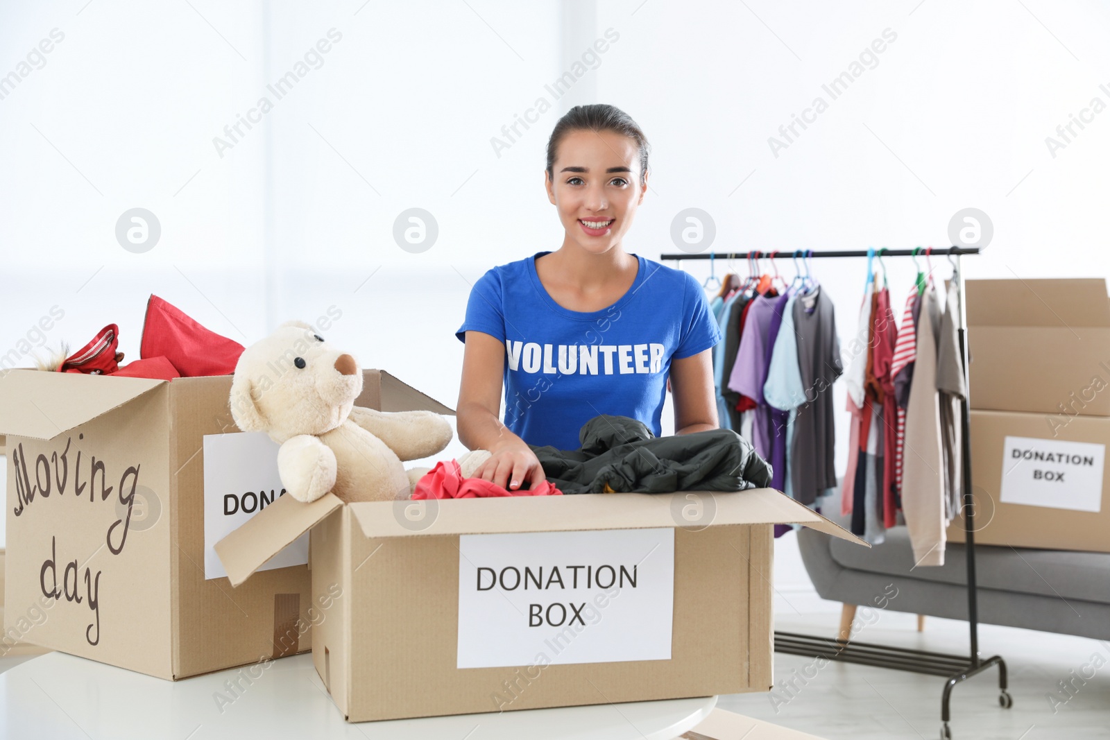 Photo of Female volunteer collecting donations at table indoors