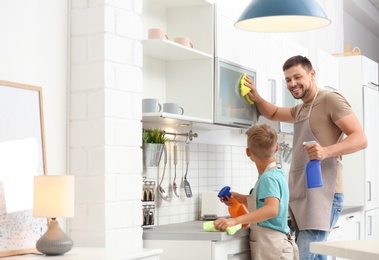 Photo of Dad and son cleaning in kitchen together