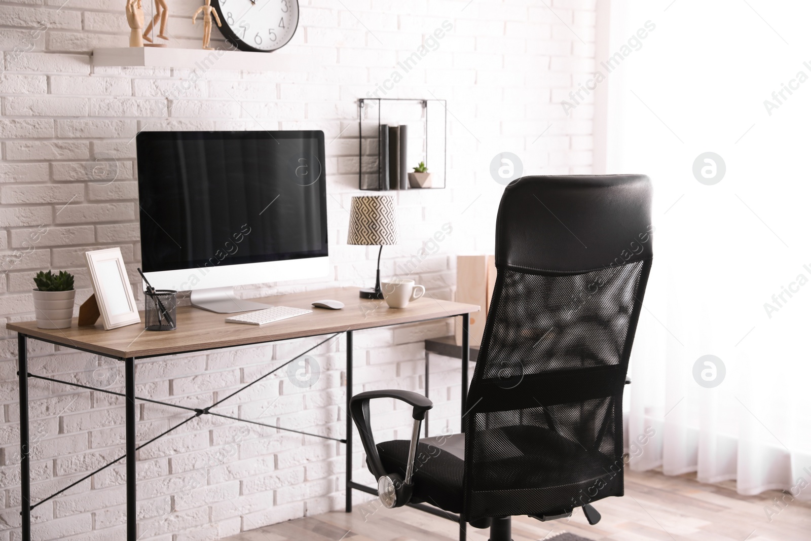 Photo of Comfortable chair near desk in modern office interior