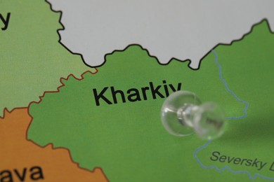 Photo of Map of Ukraine with transparent push pin placed on Kharkiv, closeup