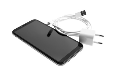 Photo of Smartphone and USB charger isolated on white. Modern technology