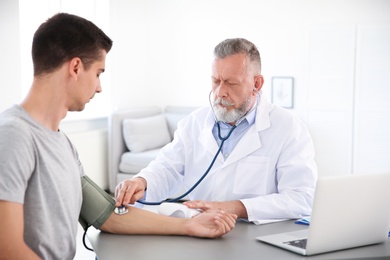 Photo of Doctor measuring patient's blood pressure in hospital