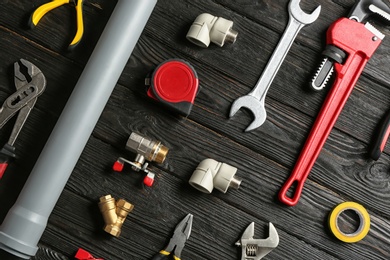 Photo of Flat lay composition with plumber's tools on wooden background