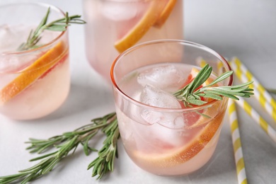 Photo of Refreshing grapefruit cocktail with rosemary on table