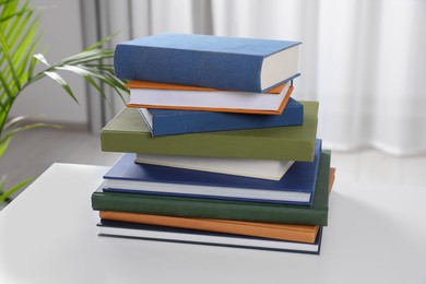 Photo of Many hardcover books on white table indoors