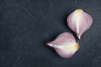 Photo of Ripe cut red onion on dark background, top view