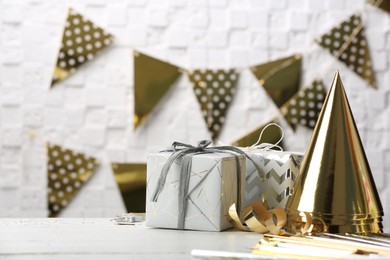 Photo of Gifts and party cones on table against blurred background