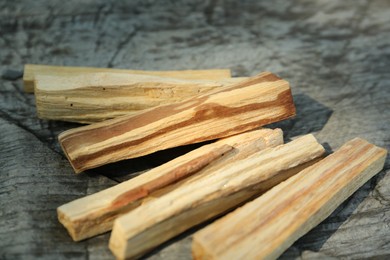 Photo of Palo santo sticks on wooden table, closeup
